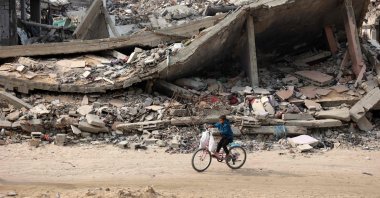 A Palestinian child rides his bicycle past a levelled building in Gaza City, Gaza Strip, Palestine, Nov. 2, 2024. (AFP Photo) 