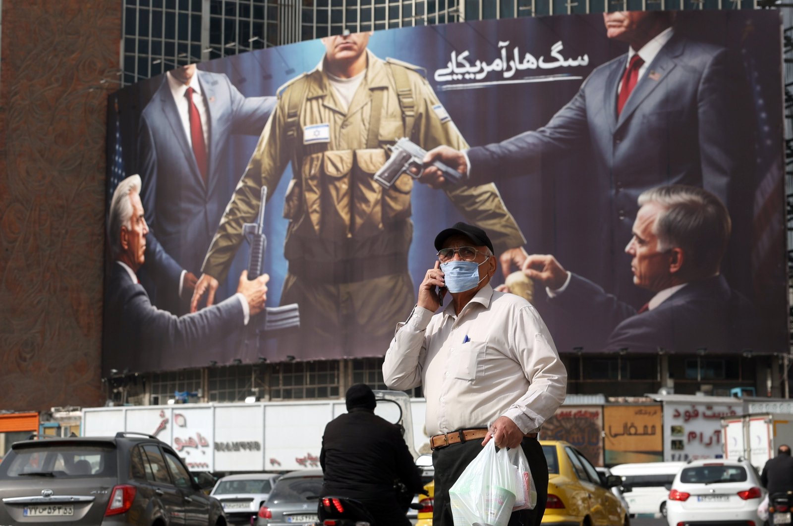 An elderly man walks past an anti-Israeli and U.S. billboard depicting an Israeli soldier receiving military supplies from the U.S. with the title "American rabid dog," at Tehran&#039;s Valiasr Square, Tehran, Iran, Oct. 28, 2024. (EPA Photo)