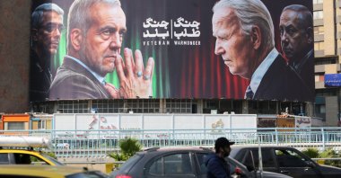 Commuters drive past a billboard bearing pictures of Iran's President Masoud Pezeshkian (2-L), armed forces chief of staff Maj. Gen. Mohammad Bagheri (L), U.S. President Joe Biden (2-R) and Israeli Prime Minister Benjamin Netanyahu in Vali-Asr square, Tehran, Iran, Oct. 27, 2024. (AFP Photo)