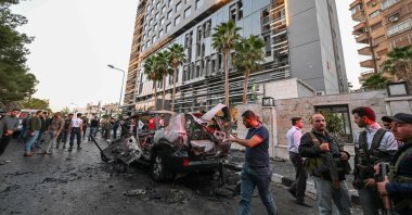 Syrian emergency and security services inspect the wreckage of a car that exploded in the Syrian capital Damascus, Oct. 21, 2024. (AFP File Photo)