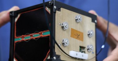 Takao Doi, a former Japanese astronaut and professor at Kyoto University, holds an engineering model of LignoSat at his laboratory at Kyoto University, Kyoto, Japan, Oct. 25, 2024. (Reuters Photo)