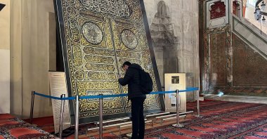 A visitor examines the silk door cover at the Old Mosque, Edirne, Türkiye, Nov. 4, 2024. (IHA Photo)