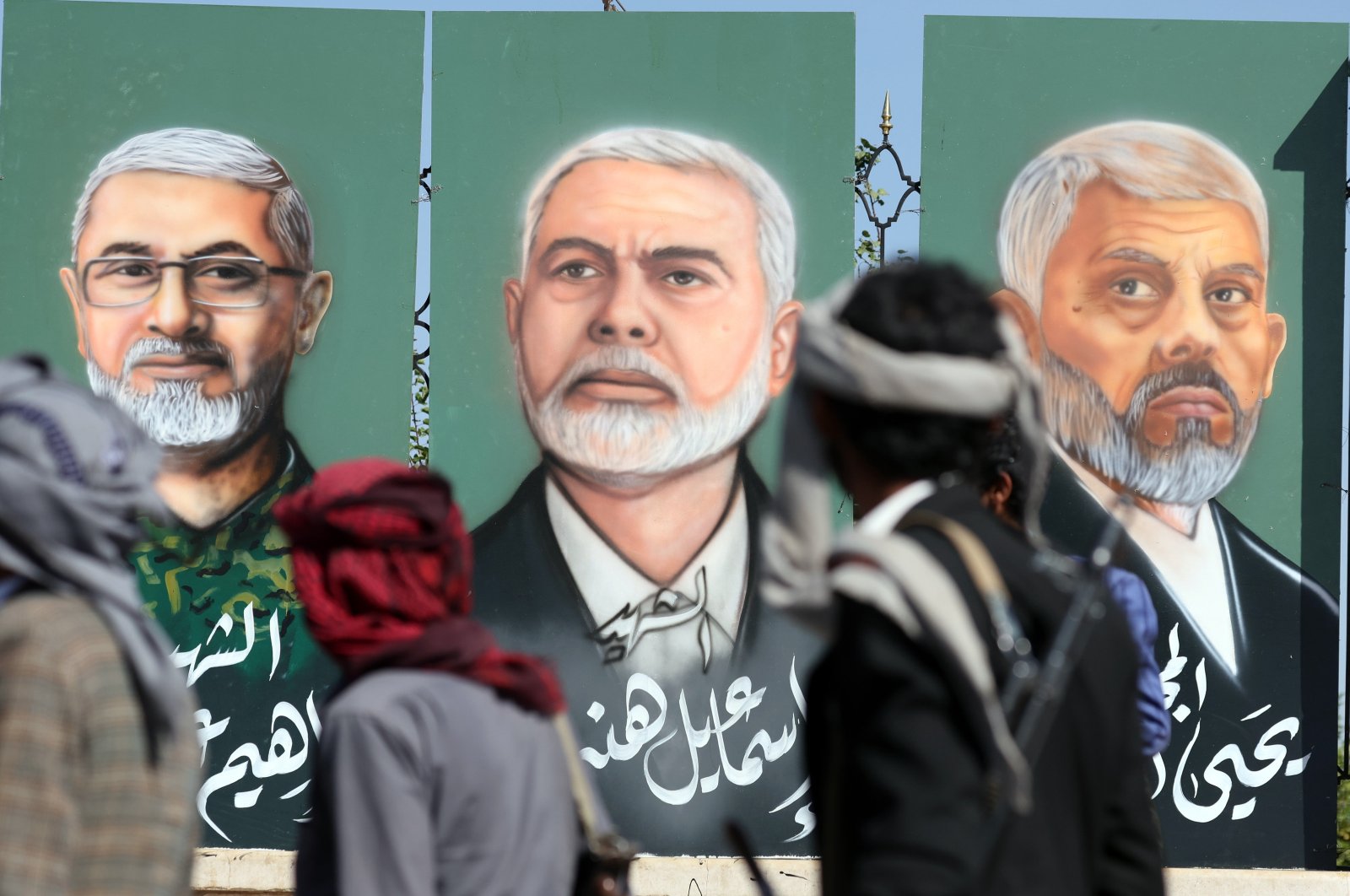 Houthi supporters pass paintings depicting (R-L) the two late Hamas leaders Yahya Sinwar and Ismail Haniyeh and late Hezbollah military commander Ibrahim Aqil on display during a rally in solidarity with the Lebanese and Palestinian people, Sanaa, Yemen, Oct. 18, 2024. (EPA Photo)