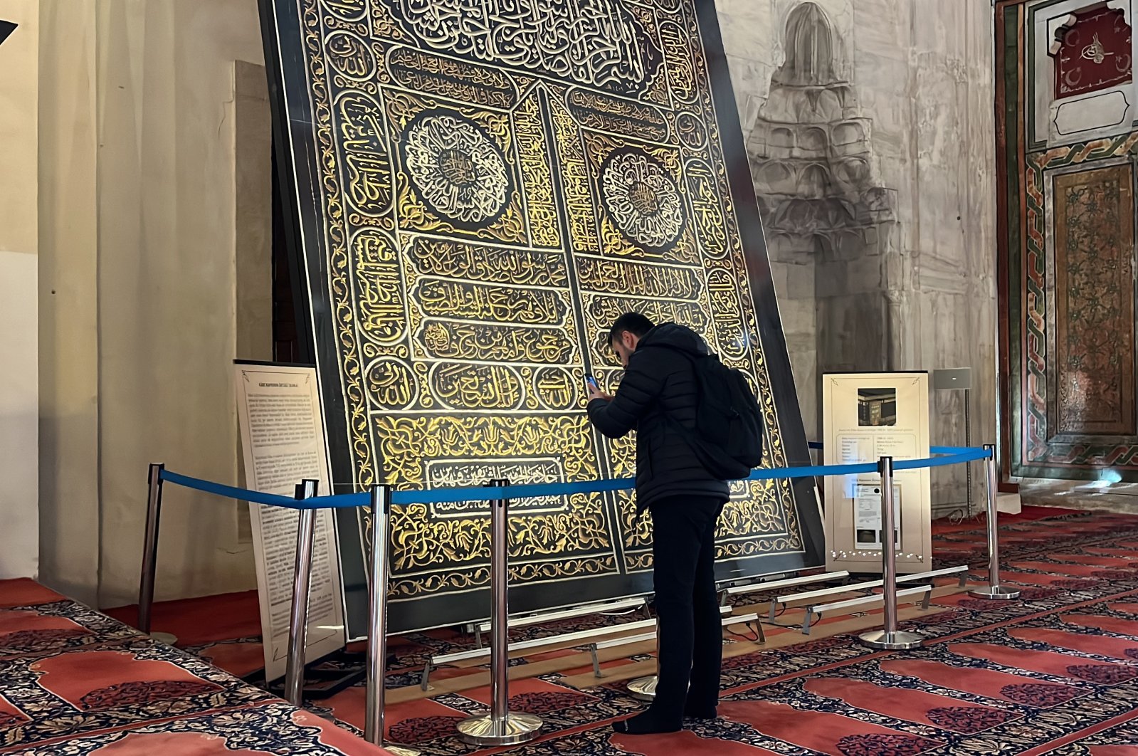 A visitor examines the silk door cover at the Old Mosque, Edirne, Türkiye, Nov. 4, 2024. (IHA Photo)