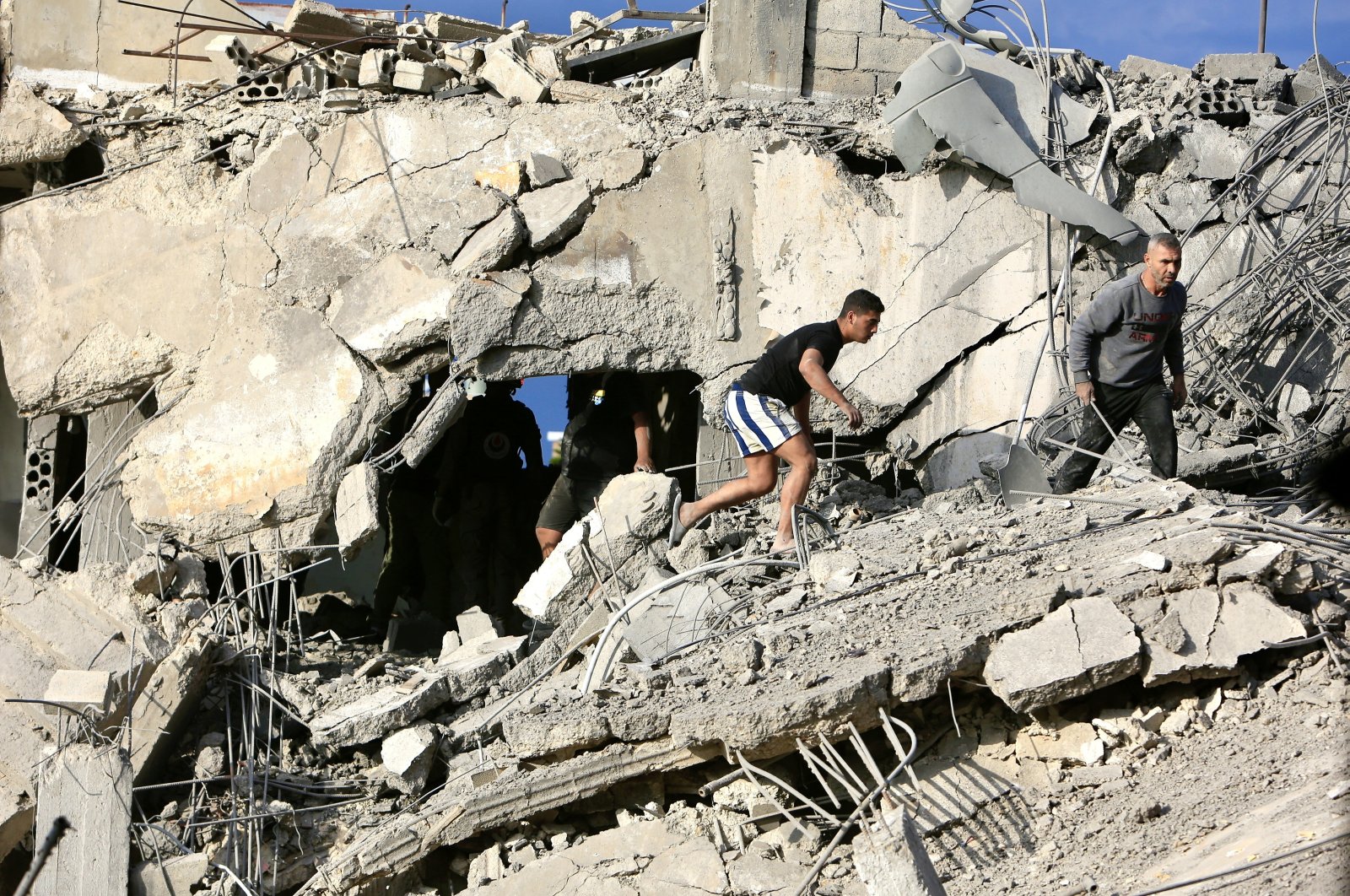 Men walk through the rubble of a building destroyed during an Israeli airstrike in Ghazieh, southern Lebanon, Nov. 3, 2024. (EPA Photo)