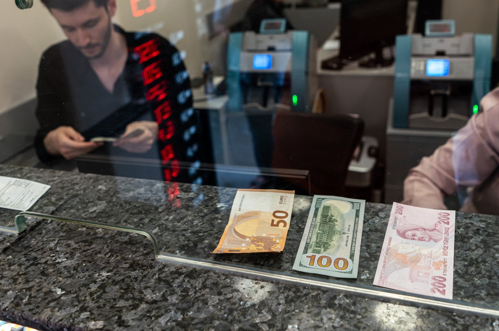 A 50 euro, 100 dollar and 200 Turkish lira banknotes are seen displayed at a currency exchange office, Istanbul, Türkiye, June 8, 2023. (Reuters Photo)