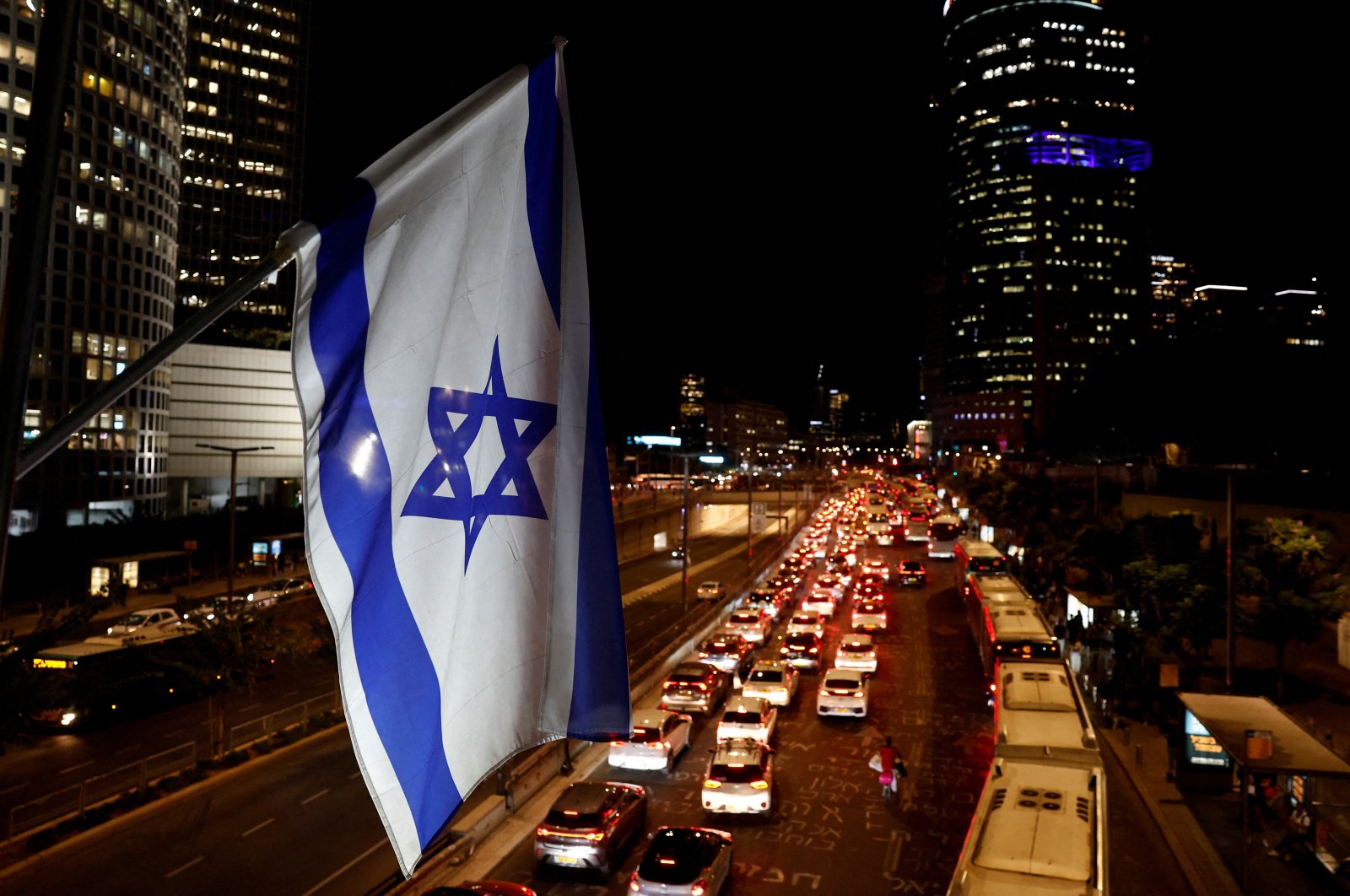 An Israeli national flag flies over a city highway during rush hour, Tel Aviv, Israel, Nov. 4, 2024. (Reuters Photo)