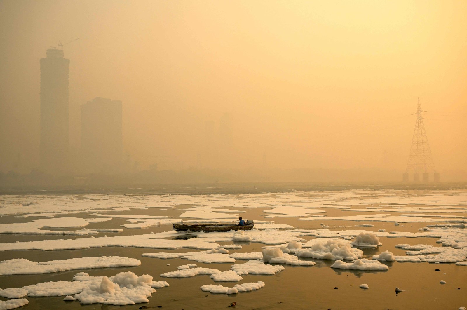 A man steers his boat across river Yamuna laden with toxic foam as smog engulfs New Delhi, India, Nov. 6, 2024. (AFP Photo)