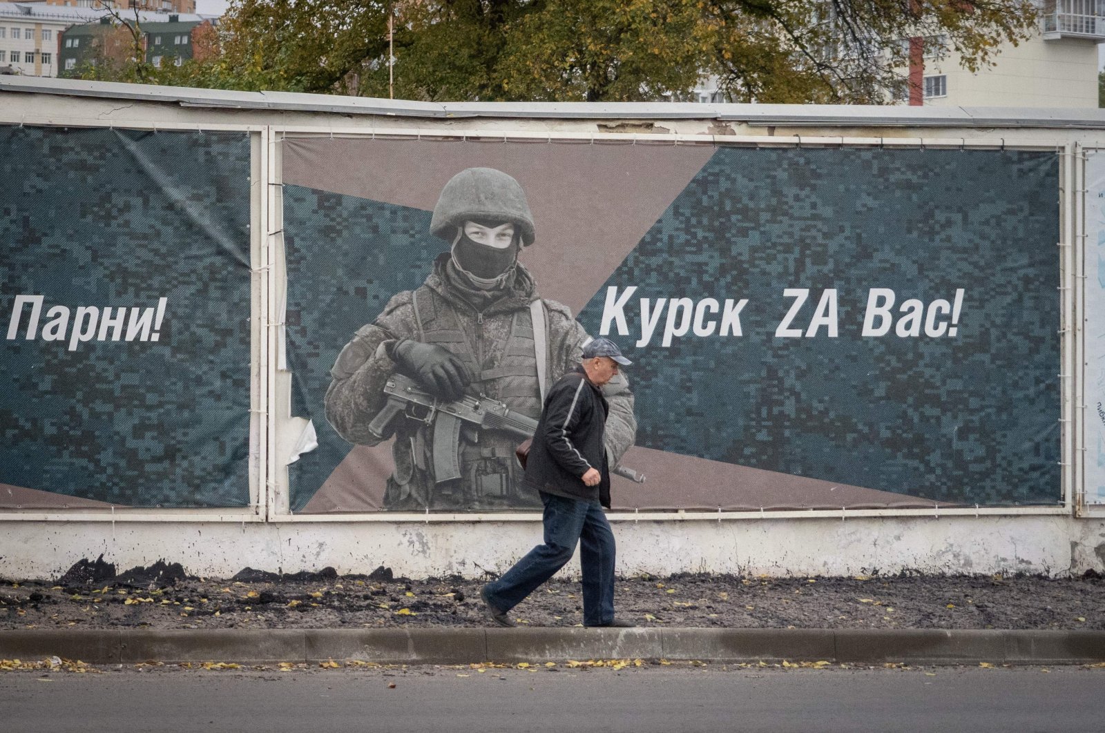 A man walks past a wall adorned with banners honoring Russian servicemen participating in Russia&#039;s military action in Ukraine, in Kursk, Oct. 17, 2024. (AFP Photo)