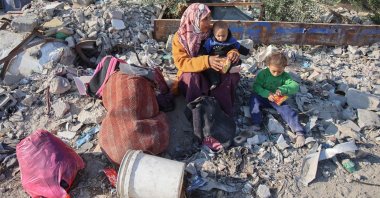 A woman rests with her children as displaced Palestinians flee Beit Lahia in the northern Gaza Strip, Palestine, Nov. 5, 2024. (AFP Photo)