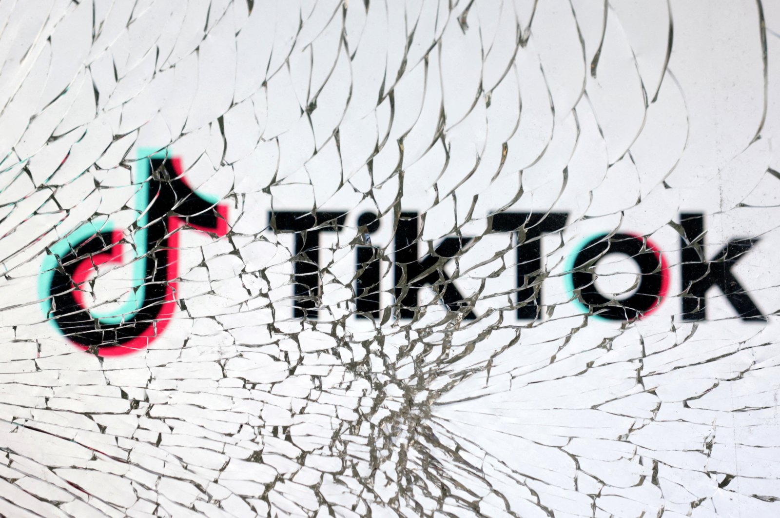 TikTok logo is seen through broken glass in this illustration taken on Jan. 25, 2023. (Reuters Photo)