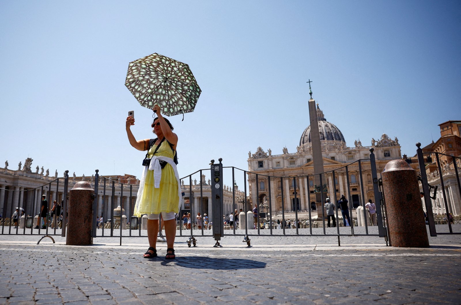 A woman takes a selfie as she shelters from the sun with an umbrella near St. Peter&#039;s Square during a heatwave in Rome, Italy, July 11, 2024. (Reuters Photo)