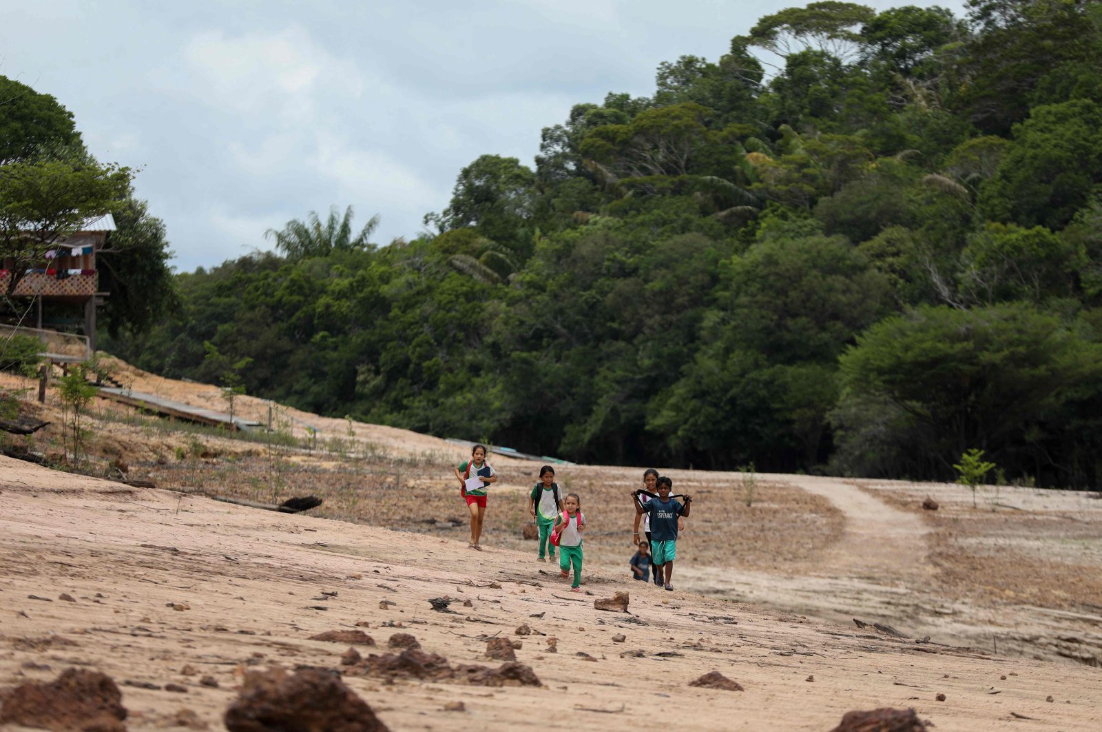 Children walk on a sandbank on their way to school in the Santo Antonio Community in Novo Airao, Amazonas state, northern Brazil, Oct. 1, 2024. (AFP Photo)