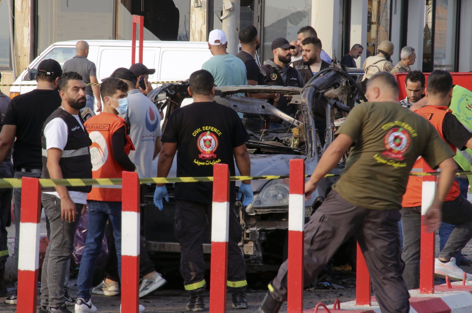 In this handout photo, civil defense workers and paramedics stand next to a charred car in an Israeli airstrike at the entrance of the southern port city, Sidon, Lebanon, Nov. 7, 2024. (AP Photo)