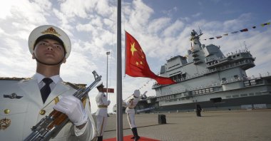 Chinese honor guard raise the Chinese flag during the commissioning ceremony of China&#039;s conventionally powered Shandong aircraft carrier at a naval port in Sanya, Hainan province, China, Dec. 17, 2019. (AP Photo)