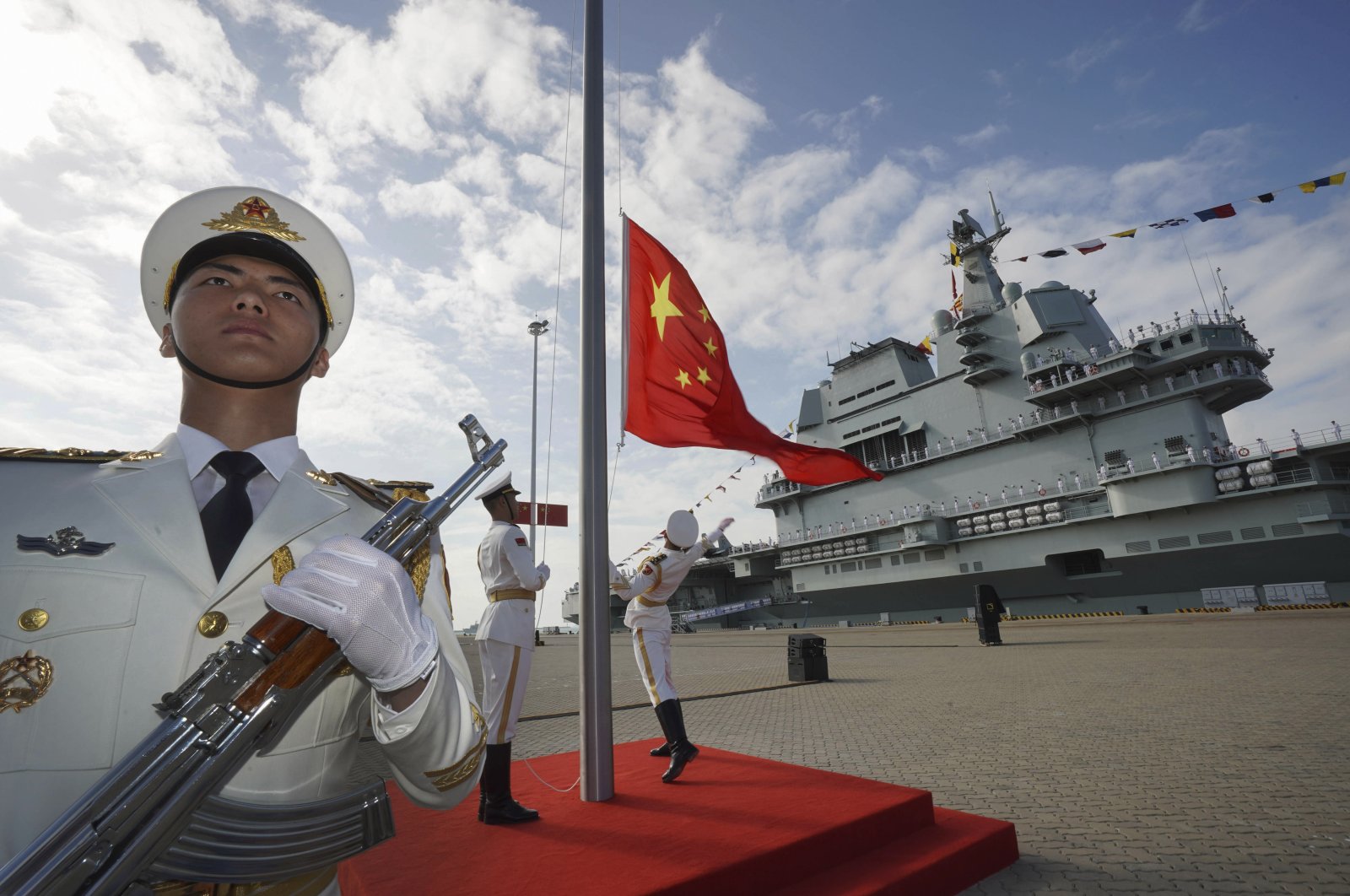 Chinese honor guard raise the Chinese flag during the commissioning ceremony of China&#039;s conventionally powered Shandong aircraft carrier at a naval port in Sanya, Hainan province, China, Dec. 17, 2019. (AP Photo)