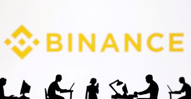 Figurines with computers and smartphones are seen in front of the Binance logo in this illustration, Feb. 19, 2024. (Reuters Photo)