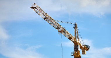 A yellow construction crane rises into the sky in Istanbul, Türkiye, Sept. 2, 2024. (Reuters Photo)