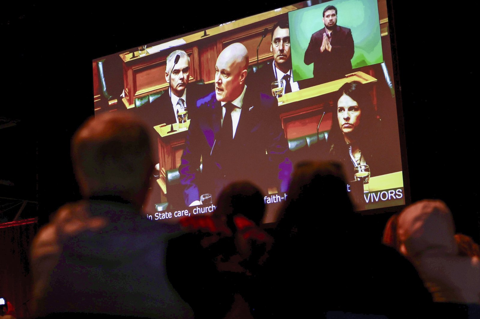 New Zealand&#039;s Prime Minister Christopher Luxon is shown on a screen as he makes a &quot;formal and unreserved&quot; apology in Parliament for the widespread abuse, torture and neglect of hundreds of thousands of children and vulnerable adults in care, Wellington, New Zealand, Nov. 12, 2024. (AP Photo)