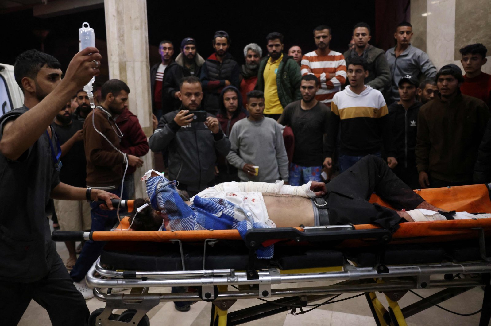 Paramedics wheel a wounded Palestinian on a gurney outside the Nasser hospital in Khan Younis following Israeli strikes on the Muwasi cafeteria, southern Gaza Strip, Nov. 11, 2024. (AFP Photo)