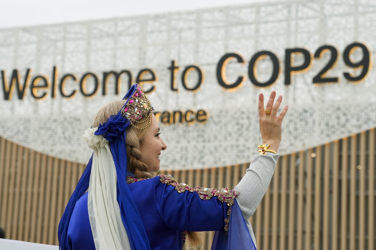 A women demonstrates with a sign on veganism at the COP29 U.N. Climate Summit, Baku, Azerbaijan, Nov. 12, 2024. (AP Photo)