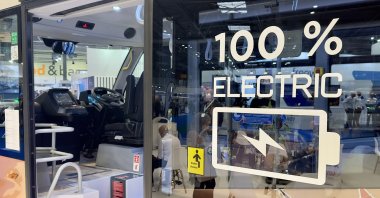 The sign reading "100% electric" of the fully electric e-JEST minibus produced by Turkish company Karsan, exhibited at the Euro Bus Expo, Birmingham, U.K., Nov. 12, 2024. (AA Photo)