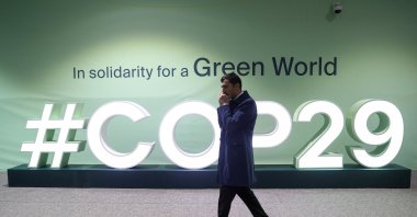 A man walks past an installation with the logo at the venue of the United Nations climate change conference, known as COP29, during a media tour ahead of the summit beginning, Baku, Azerbaijan, Nov. 8, 2024. (Reuters Photo)