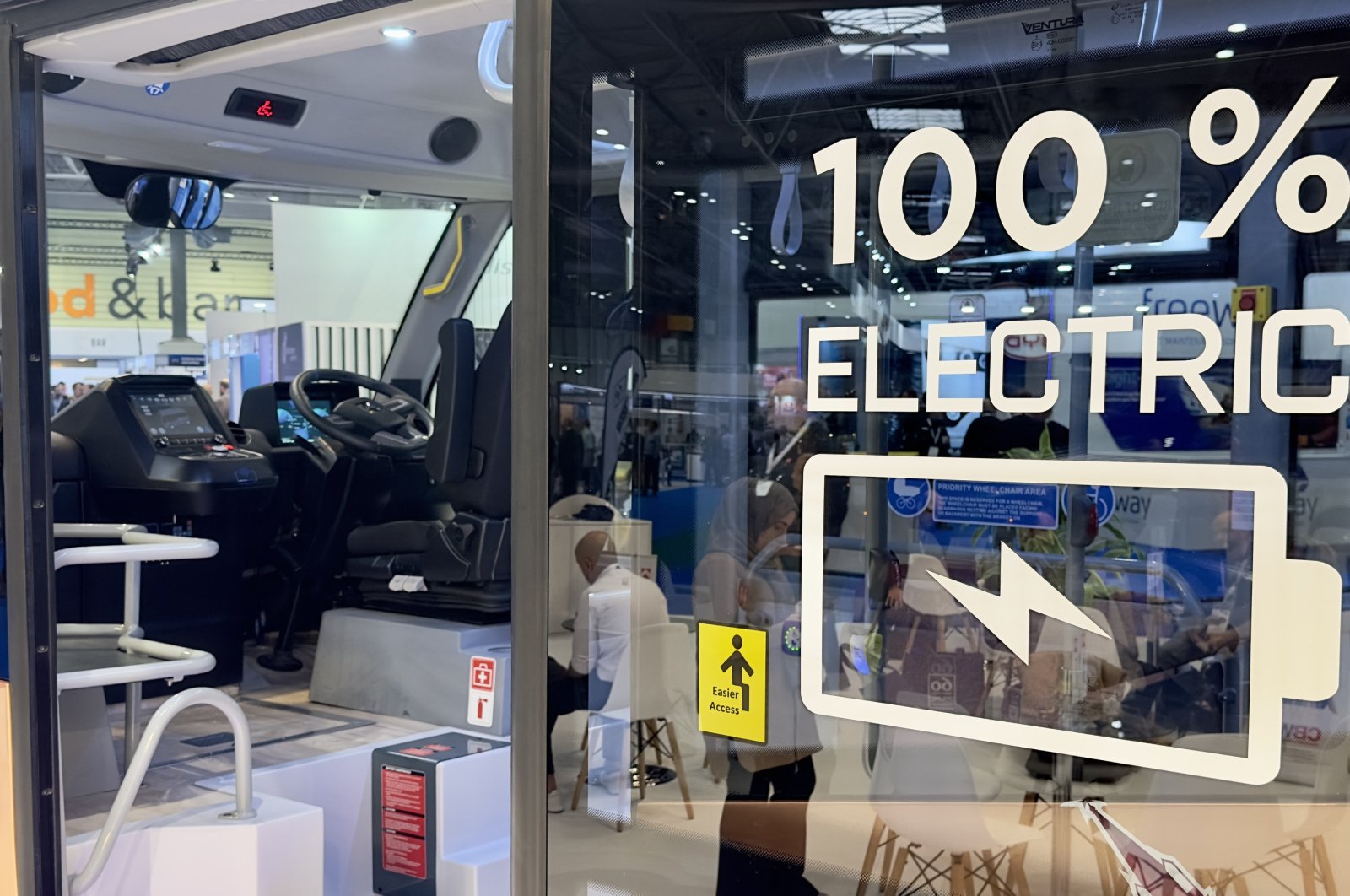 The sign reading "100% electric" of the fully electric e-JEST minibus produced by Turkish company Karsan, exhibited at the Euro Bus Expo, Birmingham, U.K., Nov. 12, 2024. (AA Photo)