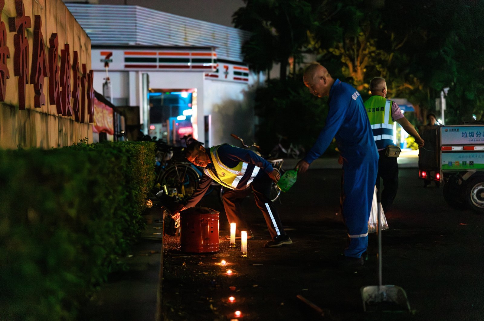 Workers remove flowers and candles left by mourners for the victims of a car ramming incident, at the entrance to the Zhuhai Sports Center, Zhuhai, China, Nov. 12, 2024. (EPA Photo)