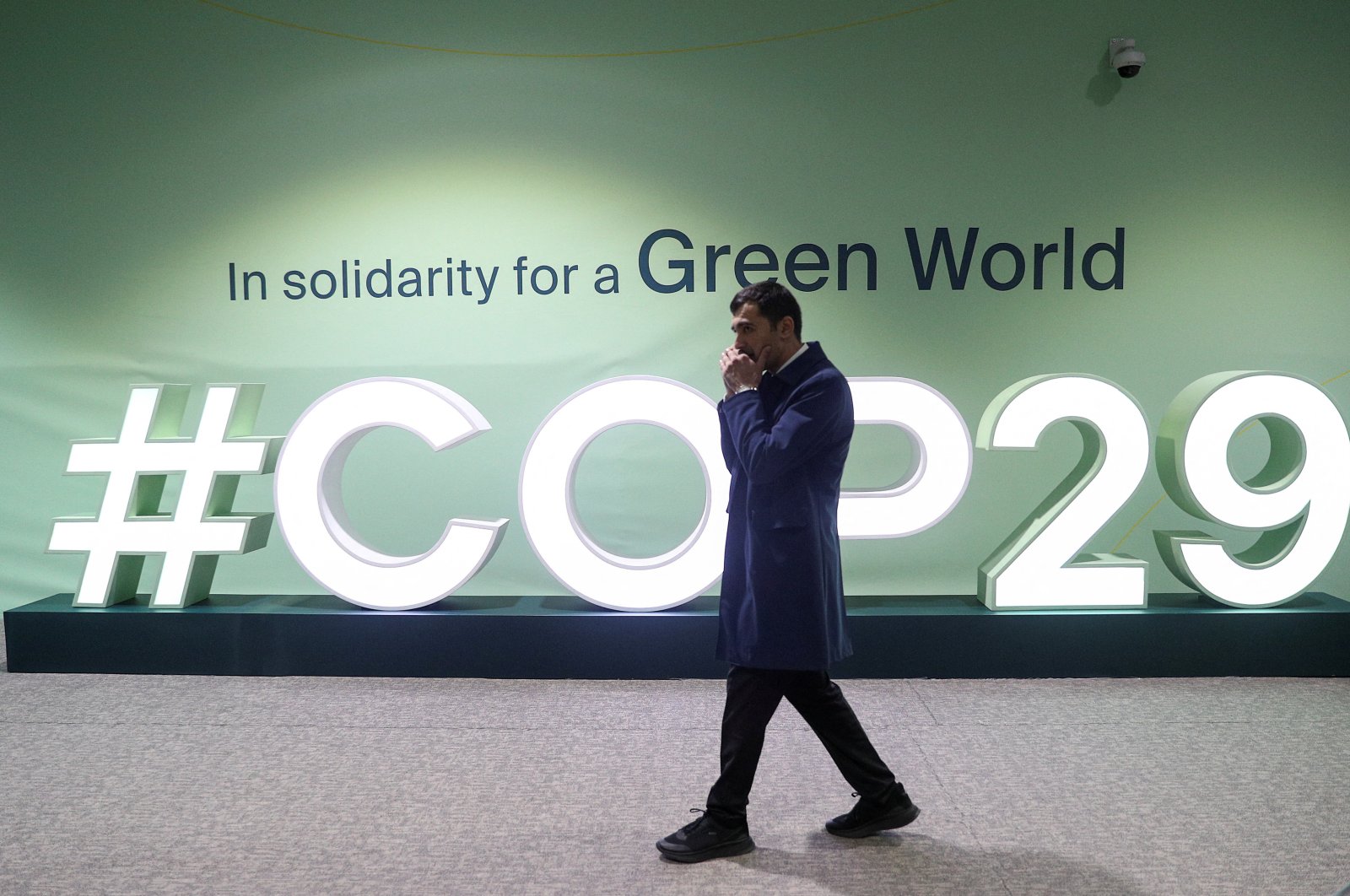 A man walks past an installation with the logo at the venue of the United Nations climate change conference, known as COP29, during a media tour ahead of the summit beginning, Baku, Azerbaijan, Nov. 8, 2024. (Reuters Photo)