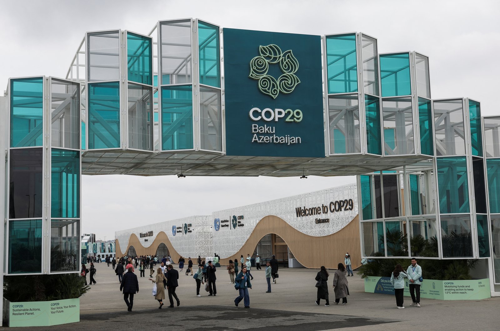 People walk past the entrance of the venue of the United Nations climate change conference COP29, Baku, Azerbaijan, Nov. 11, 2024. (Reuters Photo)