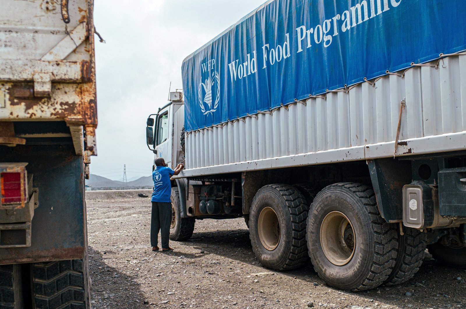 A WFP worker stands next to a truck carrying aid from Port Sudan to Sudan after Sudanese authorities extended a three-month approval to the U.N. and other aid groups to use the Adre Border crossing with Chad to reach Darfur and other famine-stricken parts, Sudan, Nov. 12, 2024. (Reuters Photo)