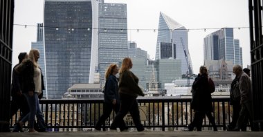 People walk along the South Bank, with the financial district of the City of London in the background, in London, Britain, Nov. 1, 2024. (EPA Photo)