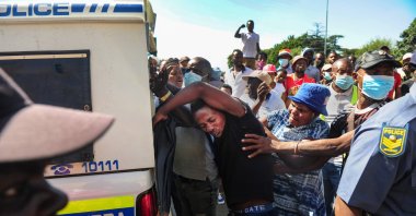 Police officers attend the scene as South African citizens, who are members of Operation Dudula, clash with foreign nationals in the Alexandra township, Johannesburg, South Africa, March 30, 2022. (Getty Images Photo)