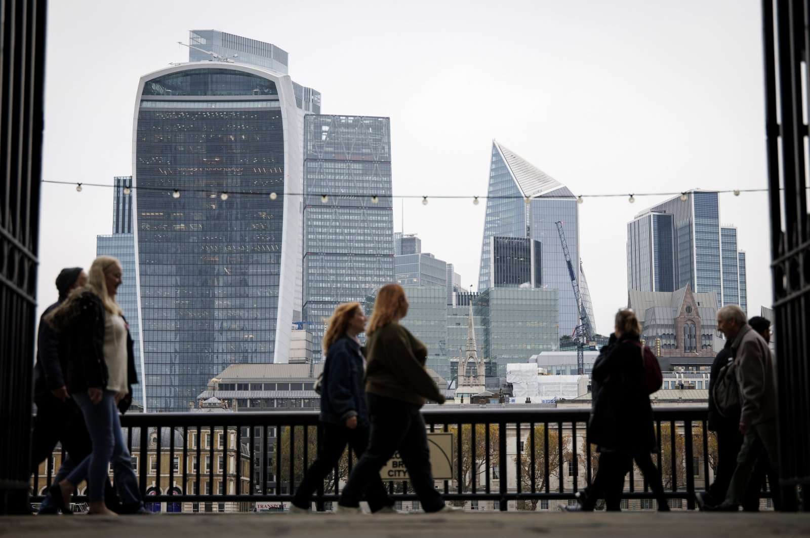 People walk along the South Bank, with the financial district of the City of London in the background, in London, Britain, Nov. 1, 2024. (EPA Photo)