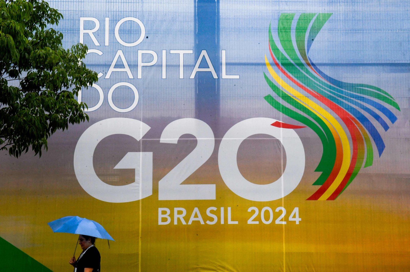 A woman walks past a sign for the G-20 summit, Rio de Janeiro, Brazil, Nov. 16, 2024. (AFP Photo)