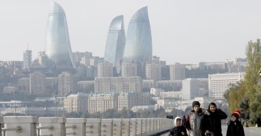 People walk along the seafront promenade with the view of the Flame Towers in Baku, the host city of COP29, Azerbaijan, Nov. 16, 2024. (EPA Photo)