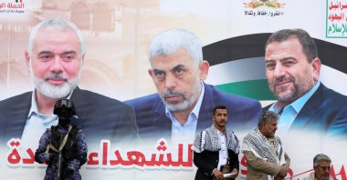 People stand in front of a banner showing (R-L) late Hamas leaders Saleh al-Arouri, Yahya Sinwar and Ismail Haniyeh during a rally, Sanaa, Yemen, Oct. 25, 2024. (EPA Photo)