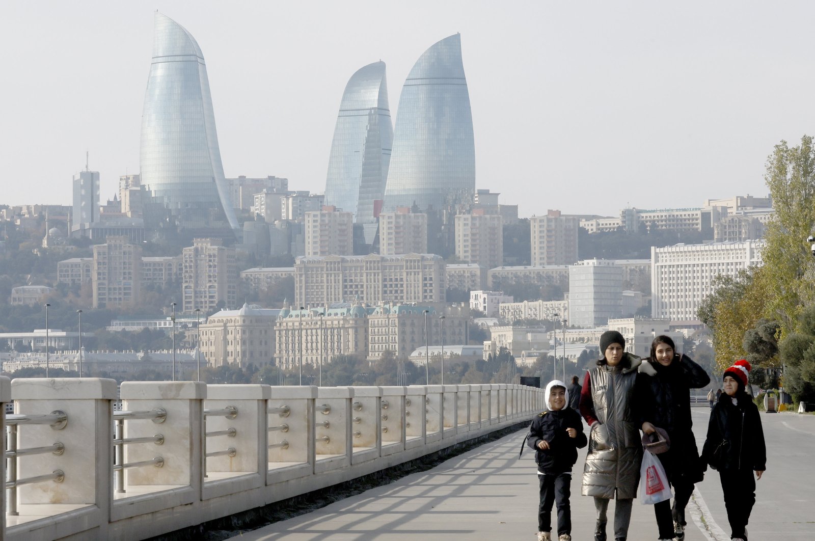 People walk along the seafront promenade with the view of the Flame Towers in Baku, the host city of COP29, Azerbaijan, Nov. 16, 2024. (EPA Photo)