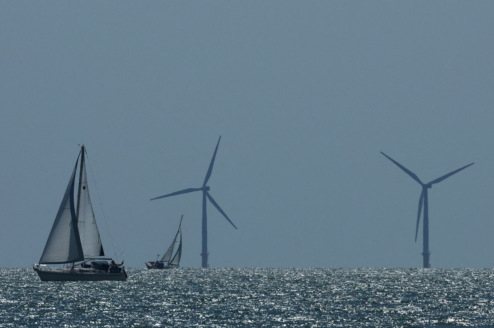 A yacht sails in front of an offshore wind farm, seen from Walton-on-the-Naze, U.K., Aug. 13, 2024. (Reuters Photo)