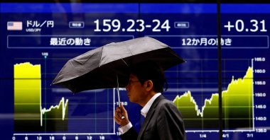 A man walks past an electronic screen displaying the current Japanese yen exchange rate against the U.S. dollar and the graph showing its recent movement in Tokyo, Japan, July 12, 2024. (Reuters Photo)