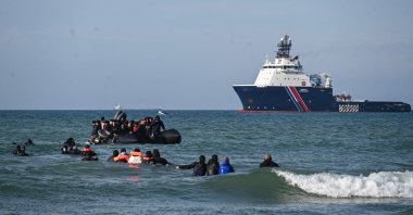 Migrants swim to board a smugglers&#039; boat in order to attempt crossing the English channel off the beach of Audresselles, northern France, Oct.  25, 2024. (AFP Photo)