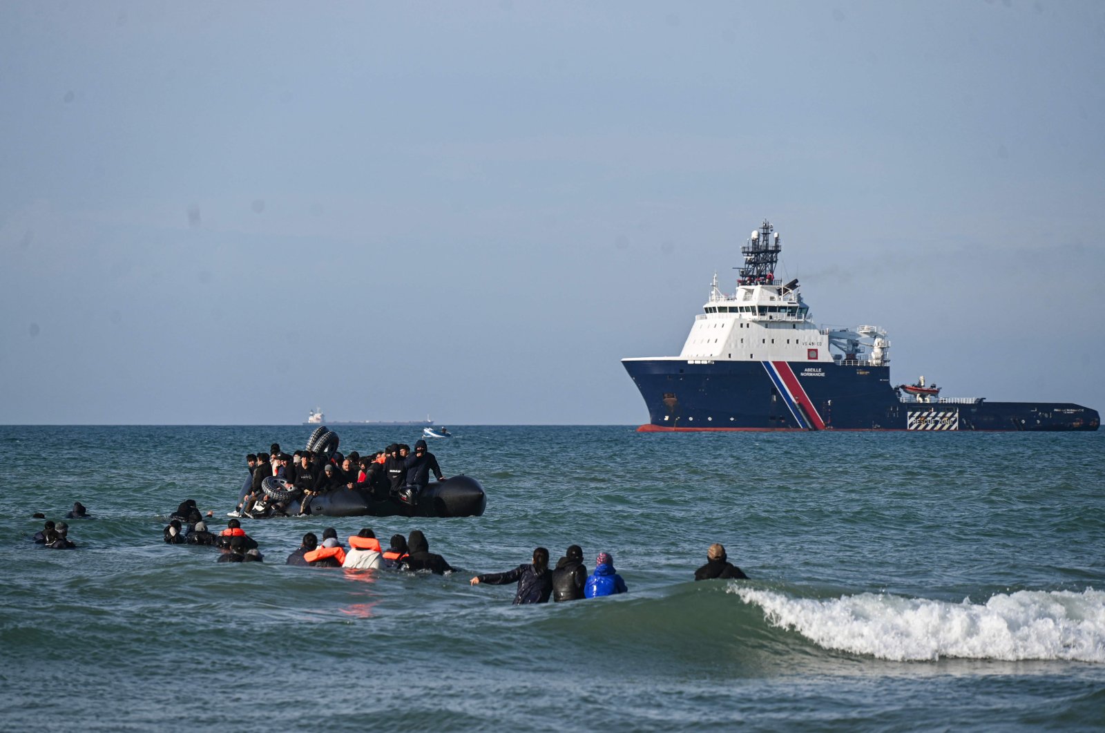 Migrants swim to board a smugglers&#039; boat in order to attempt crossing the English channel off the beach of Audresselles, northern France, Oct.  25, 2024. (AFP Photo)