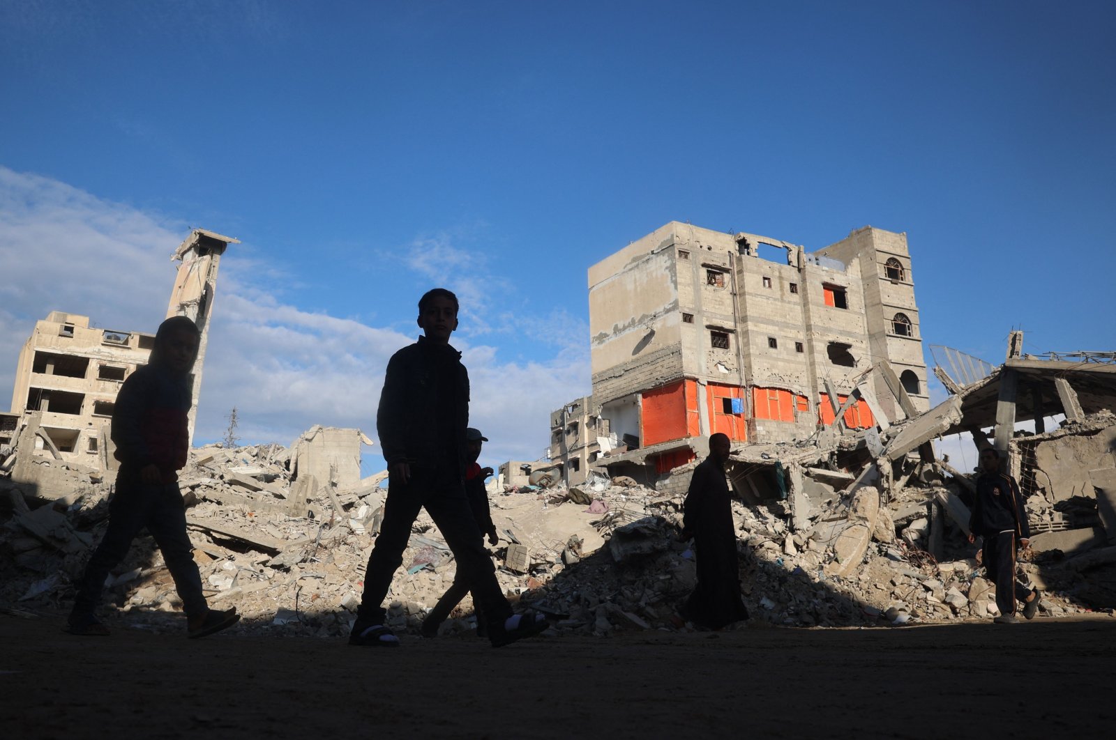  Palestinians walk past destruction following months of Israeli bombardment in the southern Gaza Strip city of Khan Younis, Nov. 19, 2024. (AFP Photo)