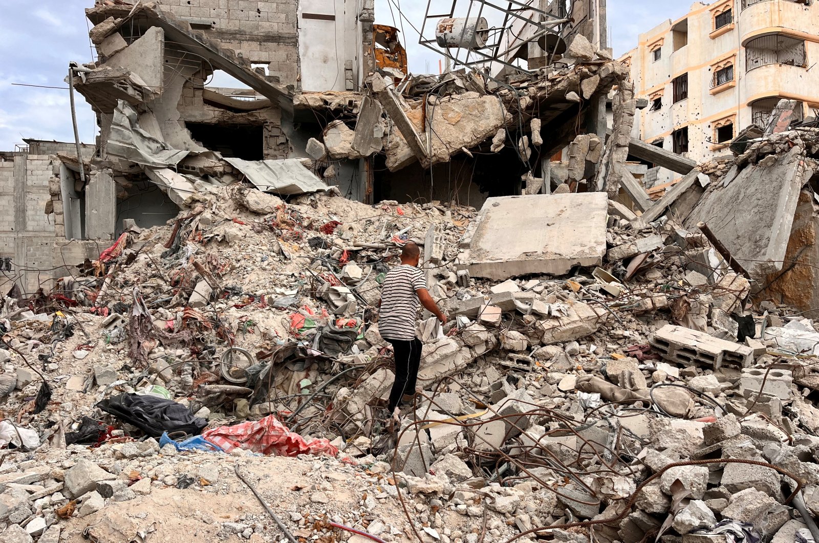 A Palestinian man searches for clothes through the rubble of a house destroyed by Israeli attacks on Khan Younis, southern Gaza Strip, Nov. 18, 2024. (Reuters Photo)