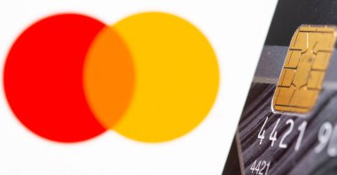 A credit card in front of the displayed Mastercard logo in this illustration taken on July 15, 2021. (Reuters Photo)