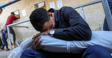 A man mourns holding the body of a child killed in an Israeli strike in the Nusseirat refugee camp, Deir al-Balah, Gaza, Palestine, Nov. 21, 2024. (AFP Photo)