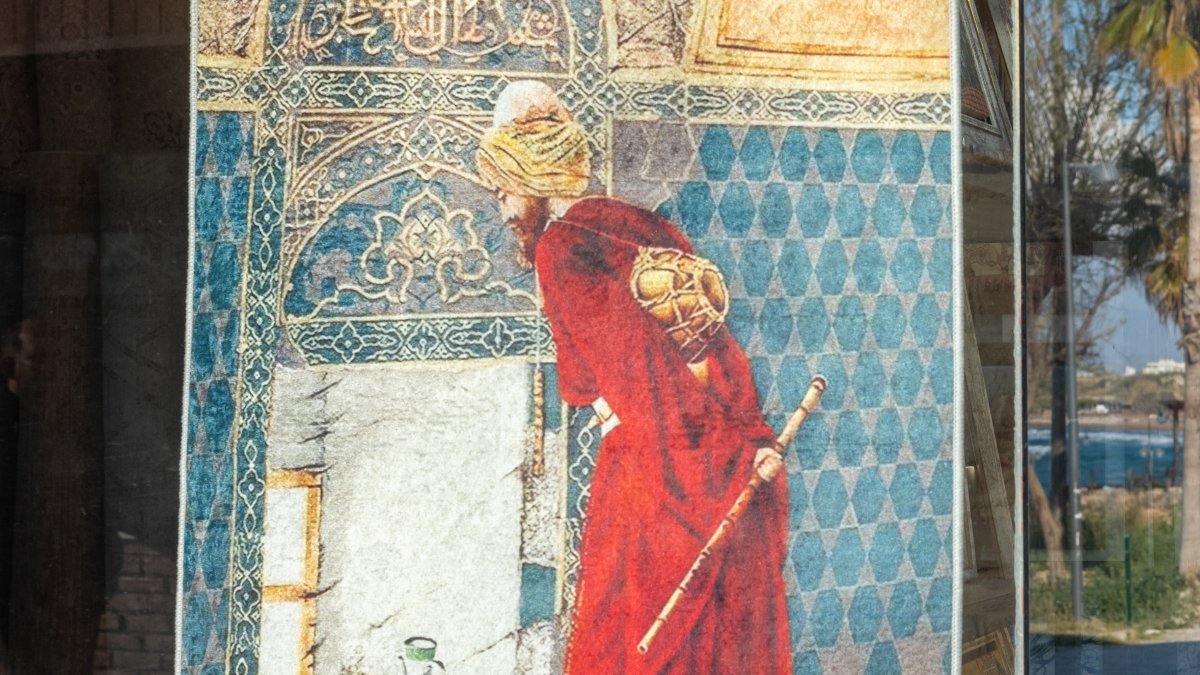 A woven rug depicting the famous Turkish painting &#039;The Tortoise Trainer&#039; by Osman Hamdi Bey. (Shutterstock)