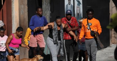 A distressed woman is being assisted when angry civilians burnt the dead bodies of suspected gang members, after an attempted overnight attack by gangs on the affluent hillside suburb Petion-Ville sparked a violent civilian response, Port-au-Prince, Haiti, Nov. 19, 2024. (Reuters Photo)