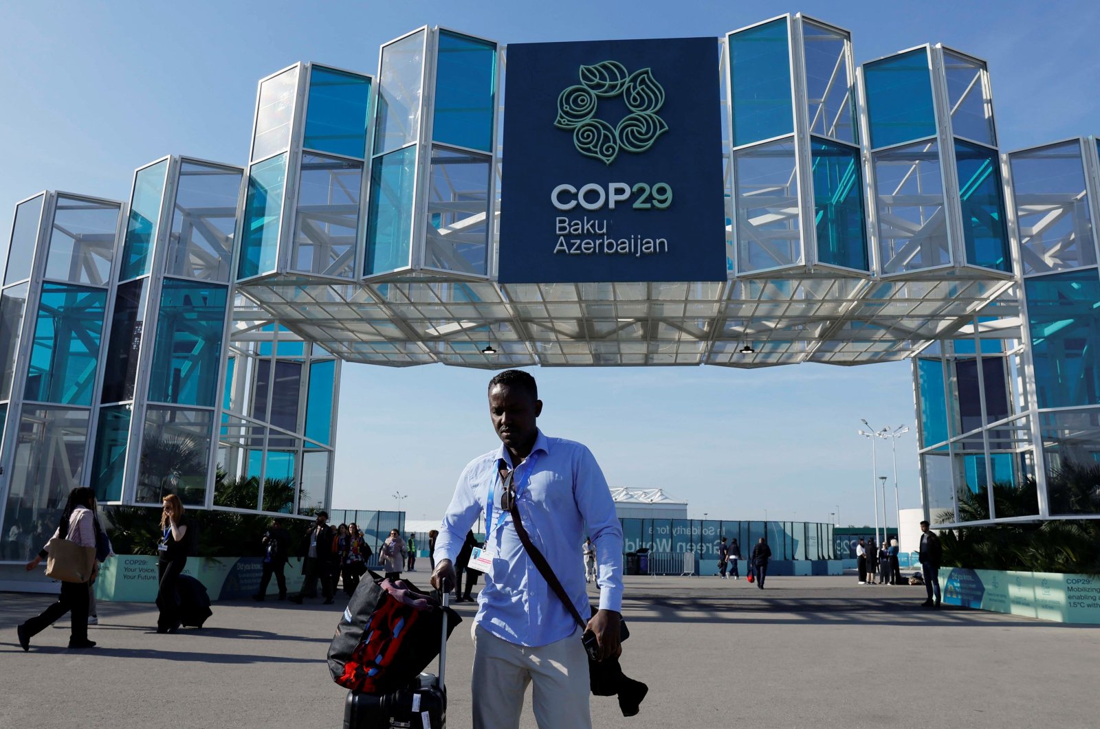 A man with a suitcase walks near the entrance of the COP29 United Nations climate change conference venue, Baku, Azerbaijan, Nov. 22, 2024. (Reuters Photo)